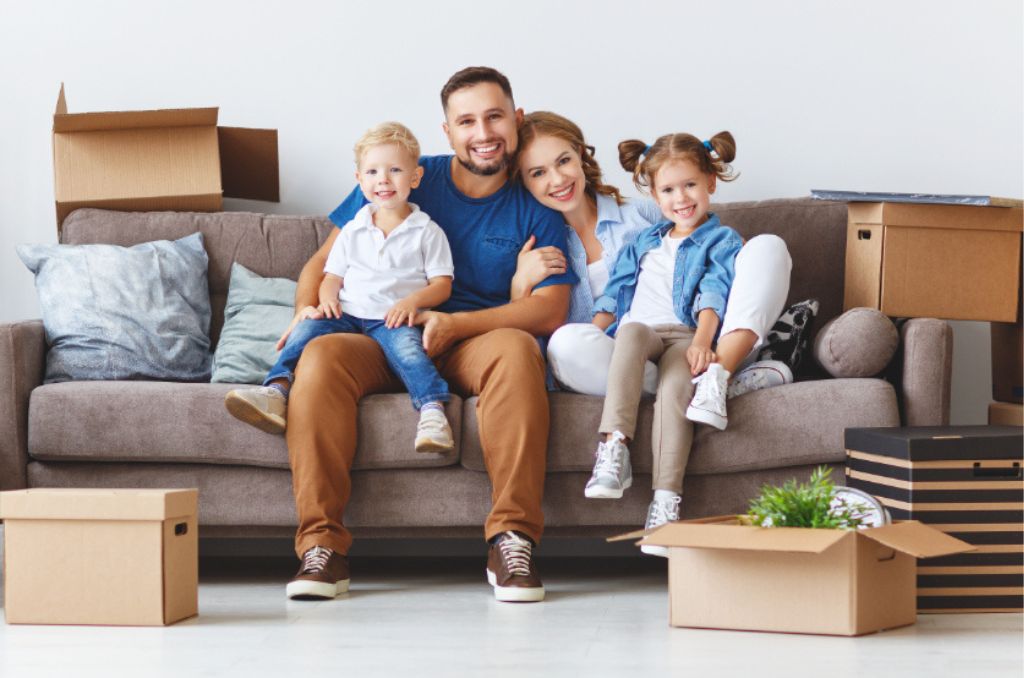 Happy family mother father and children move to a new apartment and unpack
